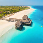 Luchtfoto van een luxe hotel op het water omringd door kristalhelder water, geschikt voor halal vakanties.