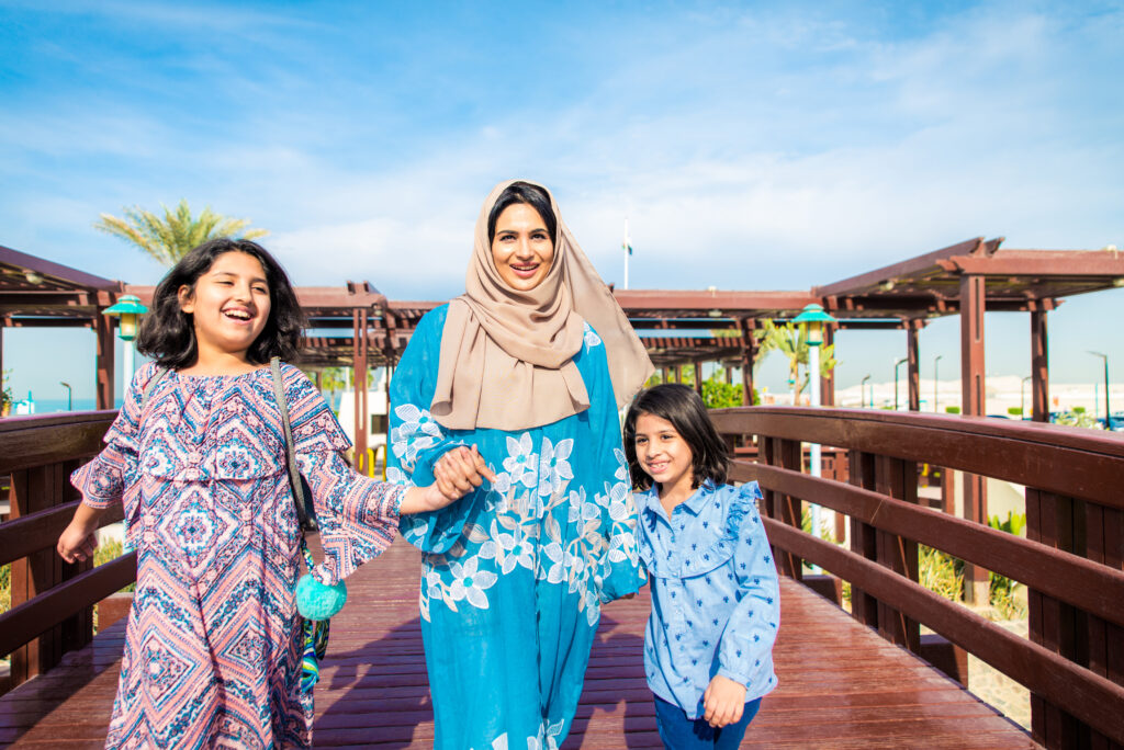 Gelukkige moslimfamilie geniet van een zonnige dag in een halalvriendelijke omgeving in Dubai.