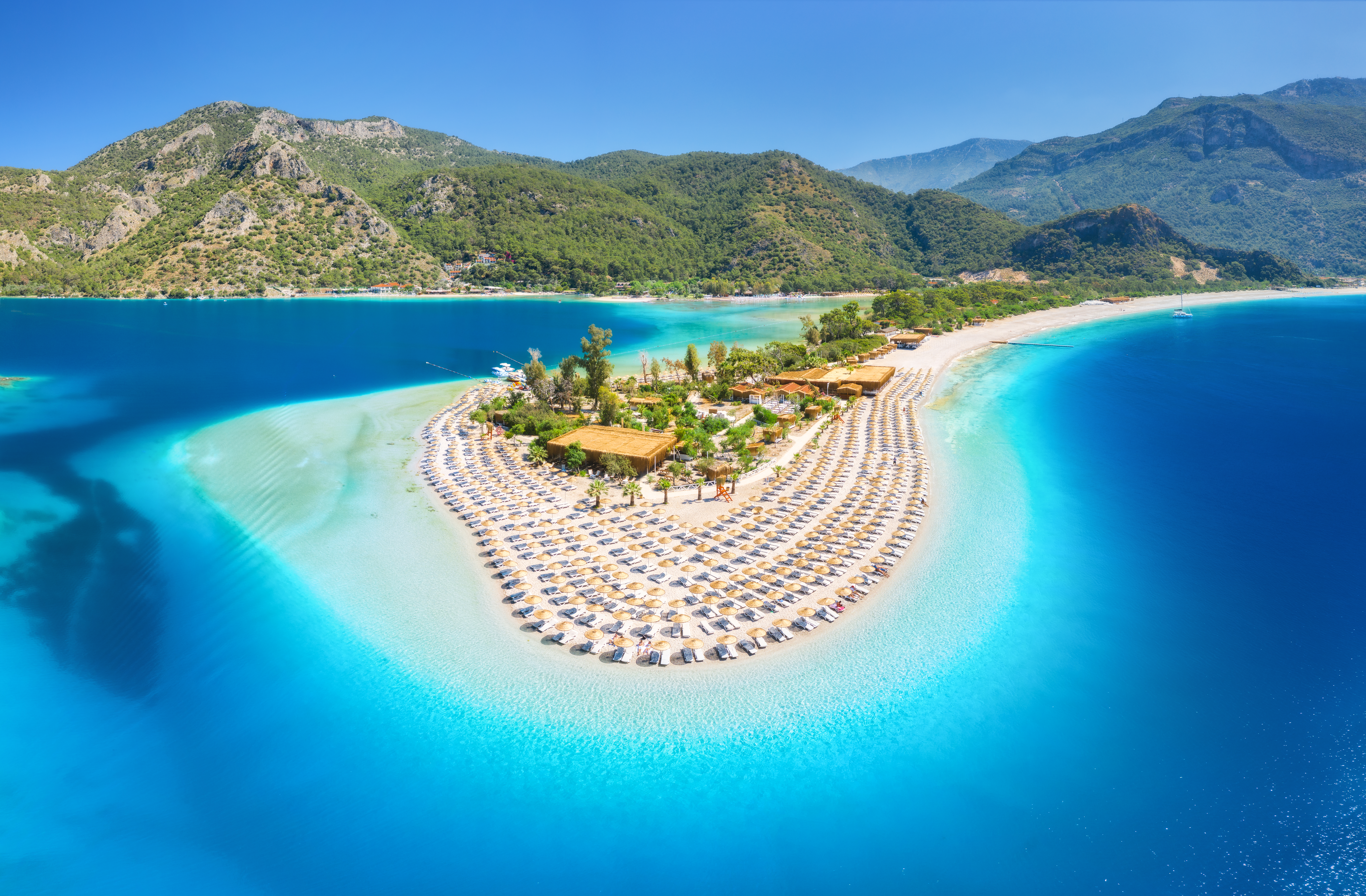 Luchtfoto van een prachtige baai met turquoise water en een zandstrand in Turkije, ideaal voor een halal vakantie.