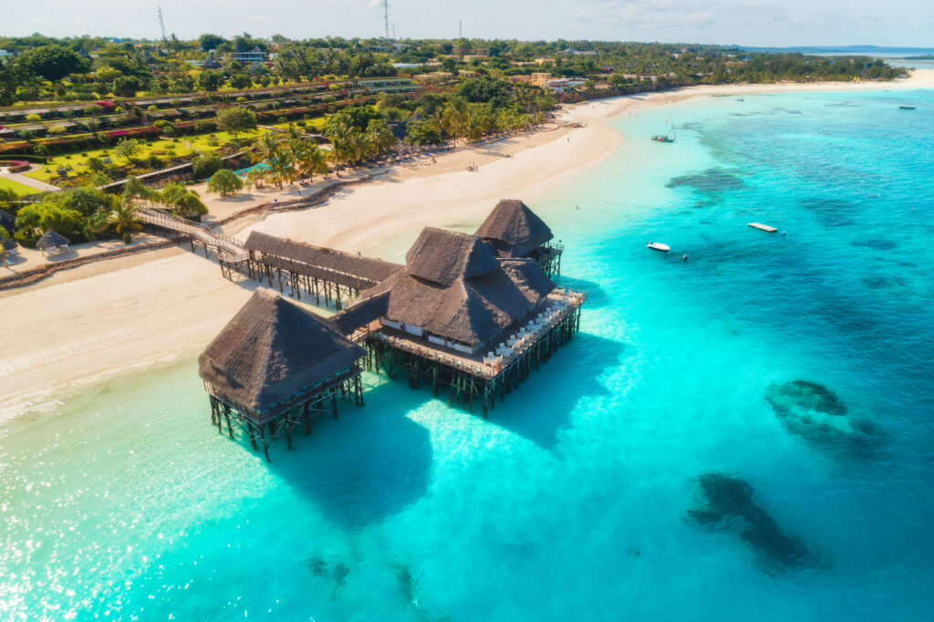 Luchtfoto van een luxe halalvriendelijk resort op palen boven turquoise zeewater, ideaal voor moslimreizigers die comfort en privacy zoeken tijdens hun vakantie.