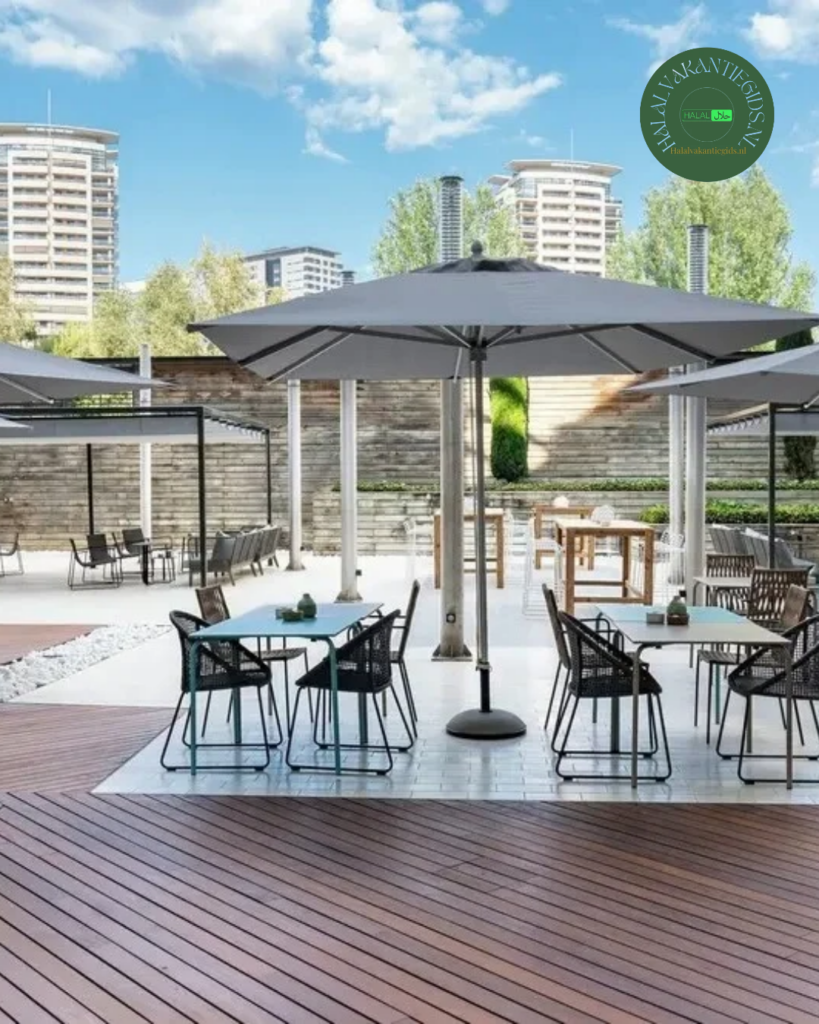Terras van Hotel Vincci Marítimo met tafels, stoelen en grote parasols.