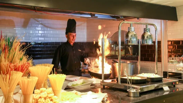 Chefkok serveert vers bereide halal gerechten in het restaurant. Chefkok bereidt halal gerechten in restaurant van Adenya Hotel & Resort