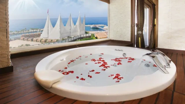 Geniet van ultieme ontspanning in uw eigen jacuzzi met panoramisch uitzicht op de Middellandse Zee. Luxe jacuzzi in Adenya Hotel & Resort met uitzicht op zee en iconische zeildoeken