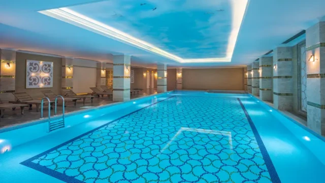 Verwarmd binnenzwembad met privacyzones Binnenzwembad van Adin Resort Hotel met luxe verlichting