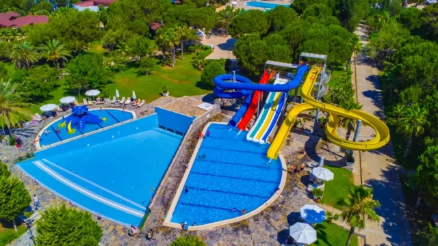Overzicht van het halalvriendelijke aquapark en zwembadfaciliteiten. Altis Resort Belek halal hotel – luchtfoto met zwembaden en glijbanen