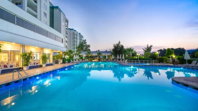 Het buitenzwembad van Modern Saraylar Hotel, ideaal voor gezinnen en halal vakanties. Modern Saraylar Hotel halal zwembad bij zonsondergang in Alanya