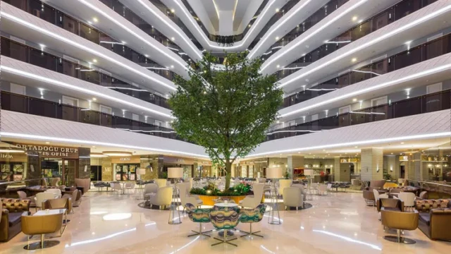 De indrukwekkende lobby van Wome Deluxe met centraal geplante boom. Moderne lobby van halal hotel Wome Deluxe Alanya Antalya