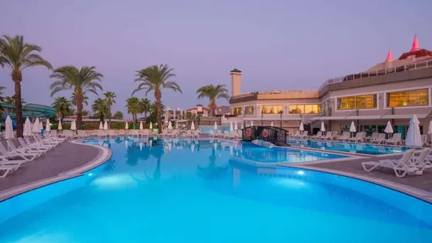 Aydinbey Famous Resort met groot buitenzwembad bij zonsondergang in Belek